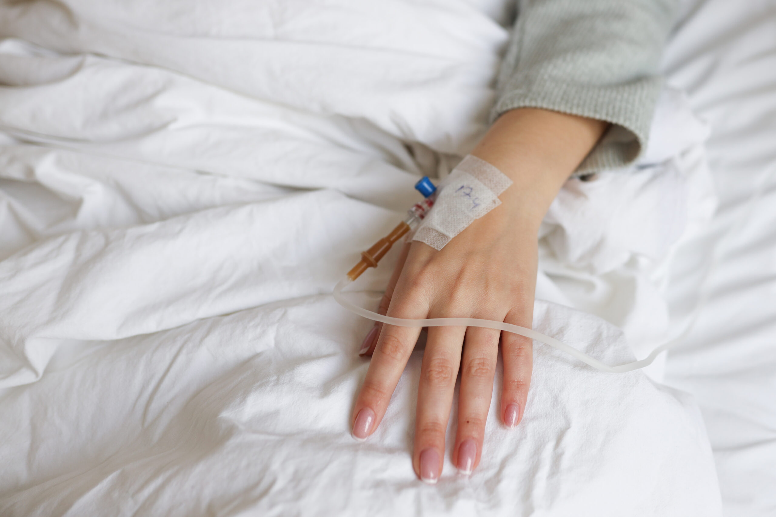Drop of saline solution drip into patients arm in the hospital.