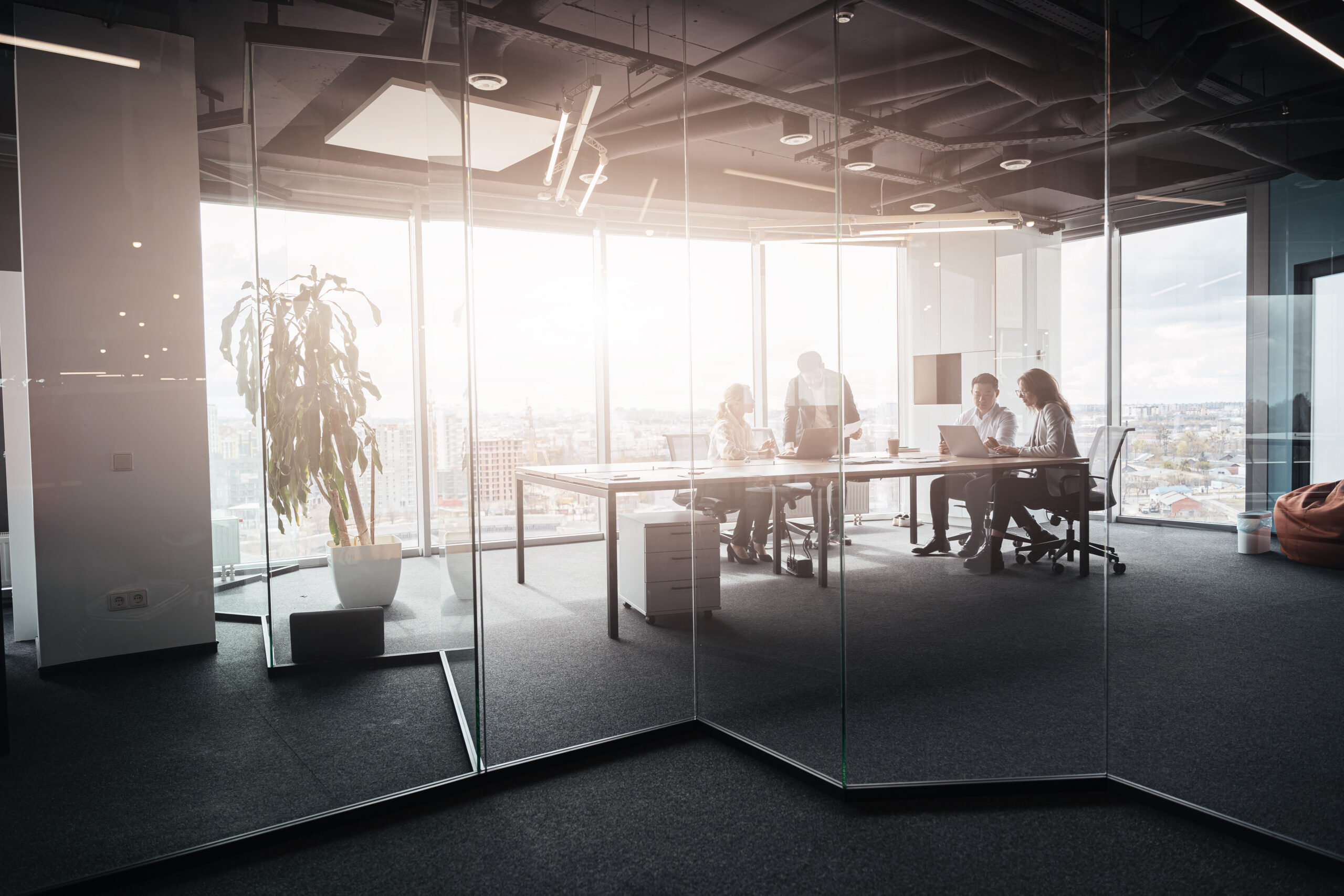 Team of businessmen communicating together after meeting in office with panoramic windows.